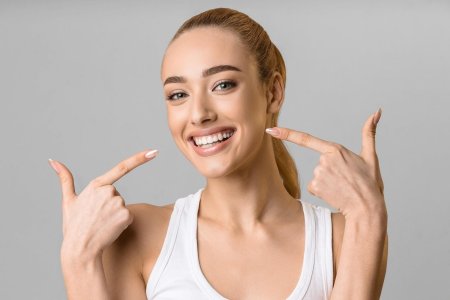 Девушка показывает зубы